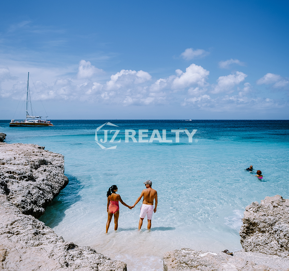 Aruba beach couple holding hands ready to buy a condo and know the hoa