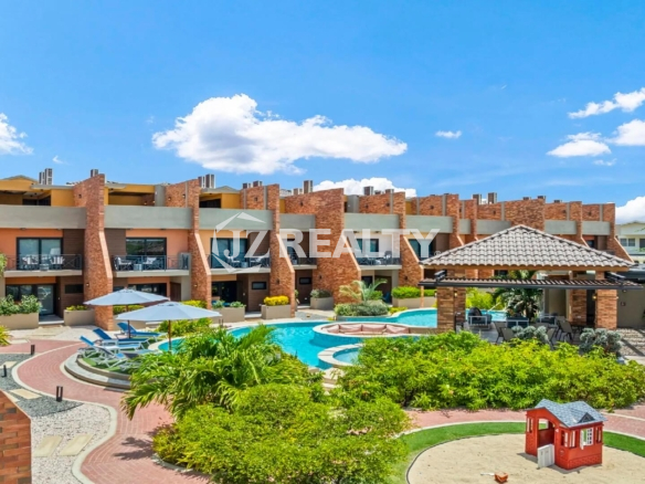 Aerial view of the Porta al Sole Townhouses surrounding the central community pool, lush landscaping, and the children's sandbox play area.