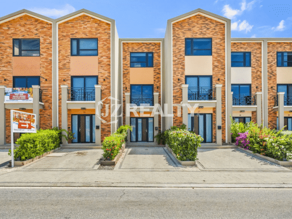 Exterior view of the modern 3-story townhouses at Porta al Sole, Noord, Aruba, featuring contemporary brick facades and balconies.