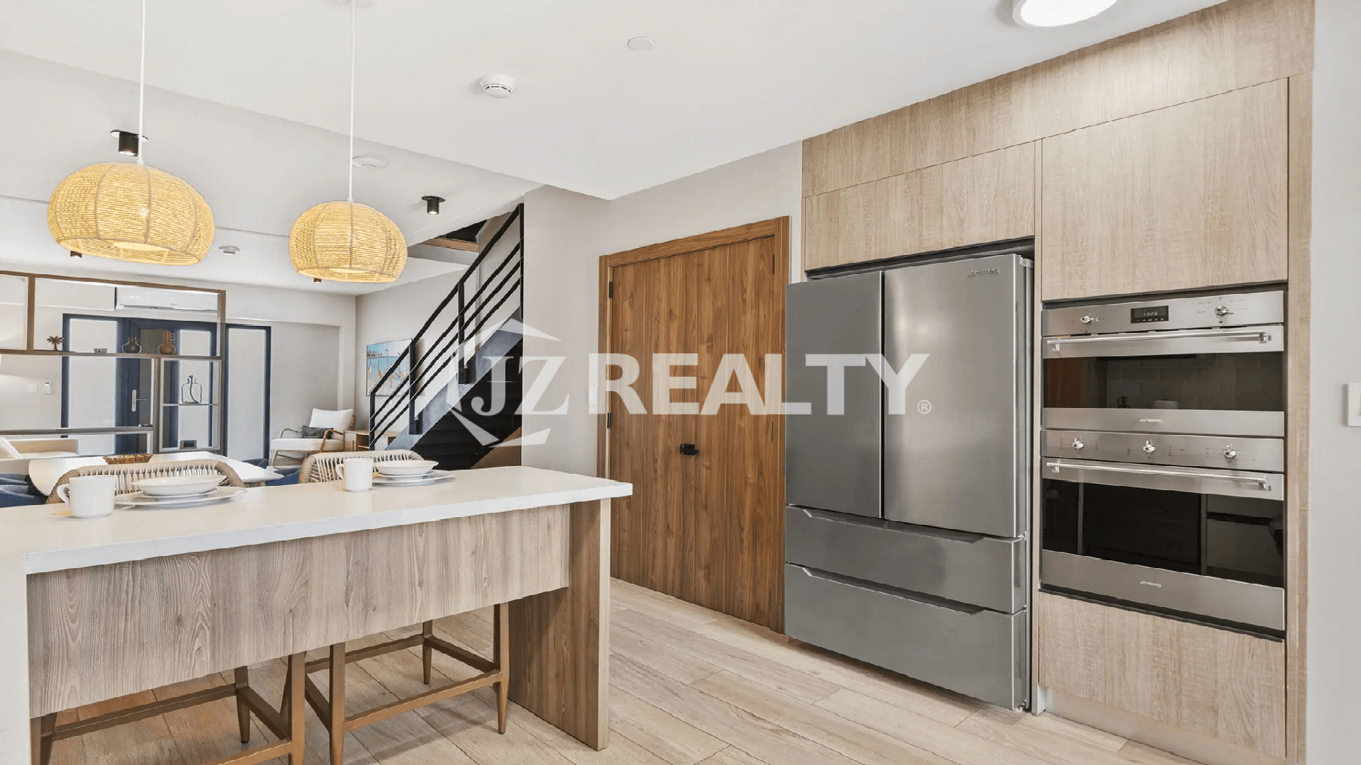 Modern kitchen design at Porta al Sole, showing stainless steel built-in appliances, a large refrigerator, and light wood-grain kitchen cabinetry.