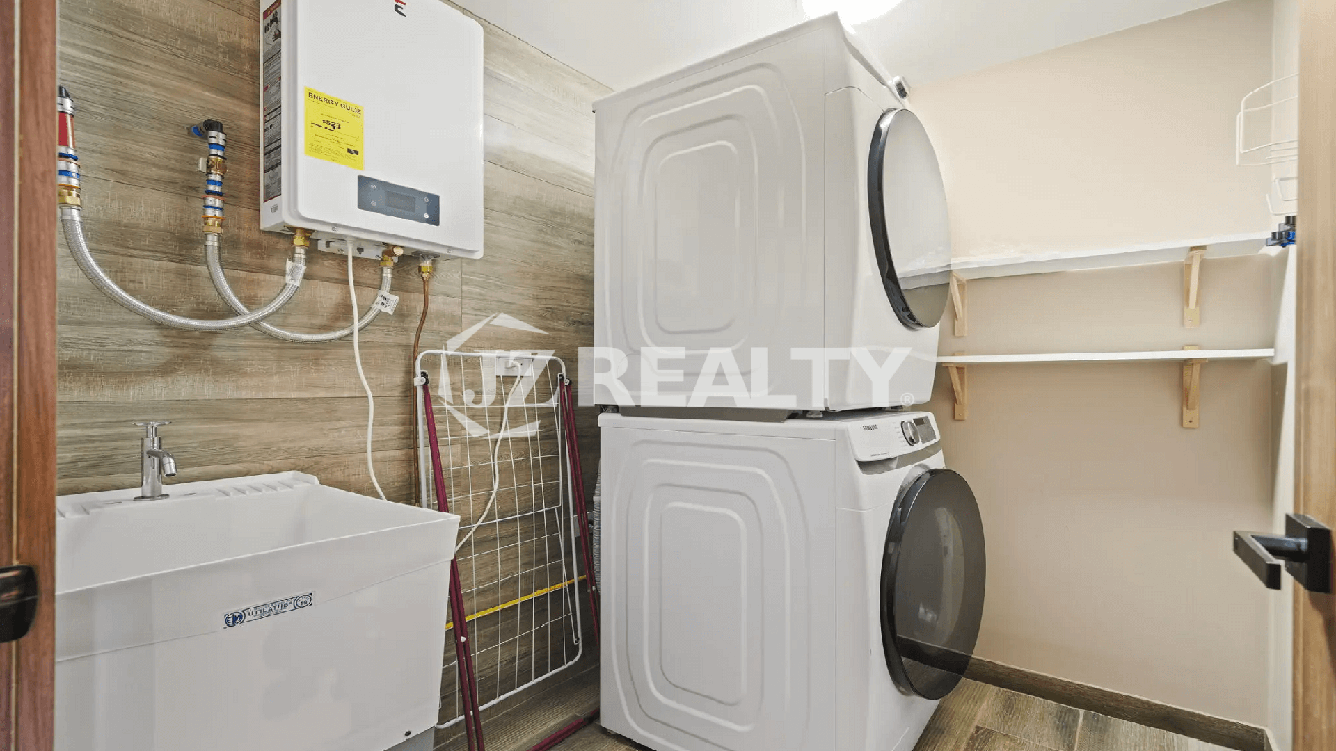 Dedicated laundry room in the Porta al Sole townhome featuring a stacked washer and dryer unit, utility sink, water heater, and storage shelves.