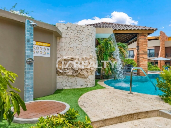 Outdoor pool shower station at Porta al Sole with a wooden platform and a stone accent wall next to the pool area.
