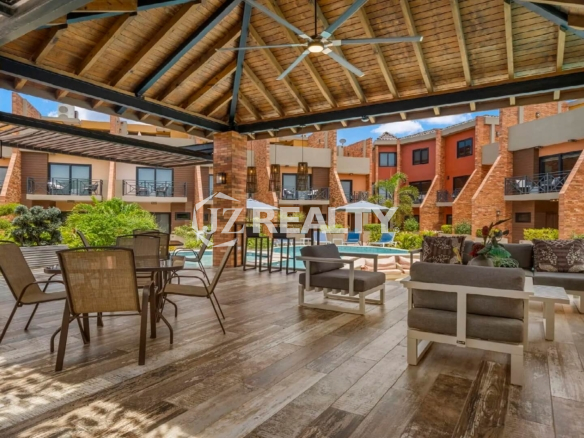 Open-air covered gazebo structure next to the Porta al Sole pool, featuring a dining area, cushioned outdoor seating, and ceiling fans.