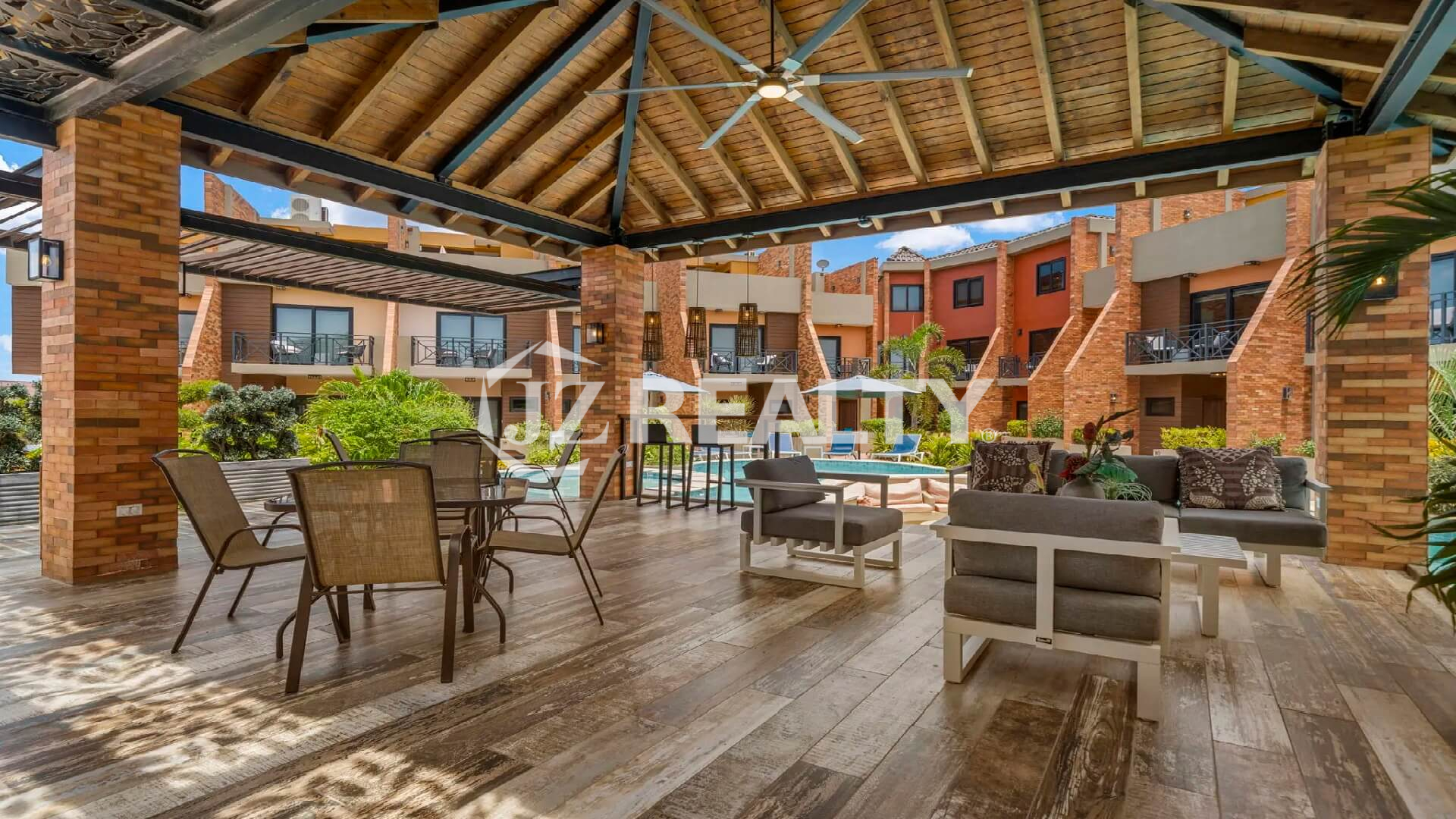 Open-air covered gazebo structure next to the Porta al Sole pool, featuring a dining area, cushioned outdoor seating, and ceiling fans.