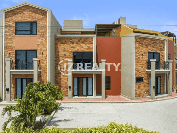 Exterior view of the brick and stucco multi-story buildings at the Porta al Sole complex, showing unit entrances and private balconies.