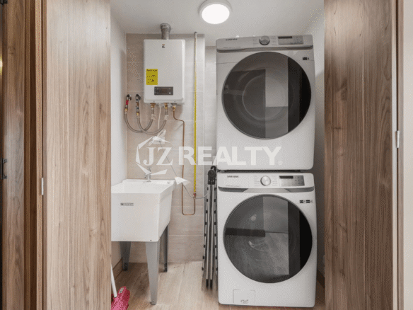 Dedicated laundry closet in Porta al Sole Unit 12 with stacked Samsung washer and dryer, a utility sink, and a wall-mounted water heater.