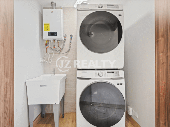 Dedicated laundry area in Porta al Sole Unit 13 with a stacked white washer and dryer unit, utility sink, and wall-mounted water heater.