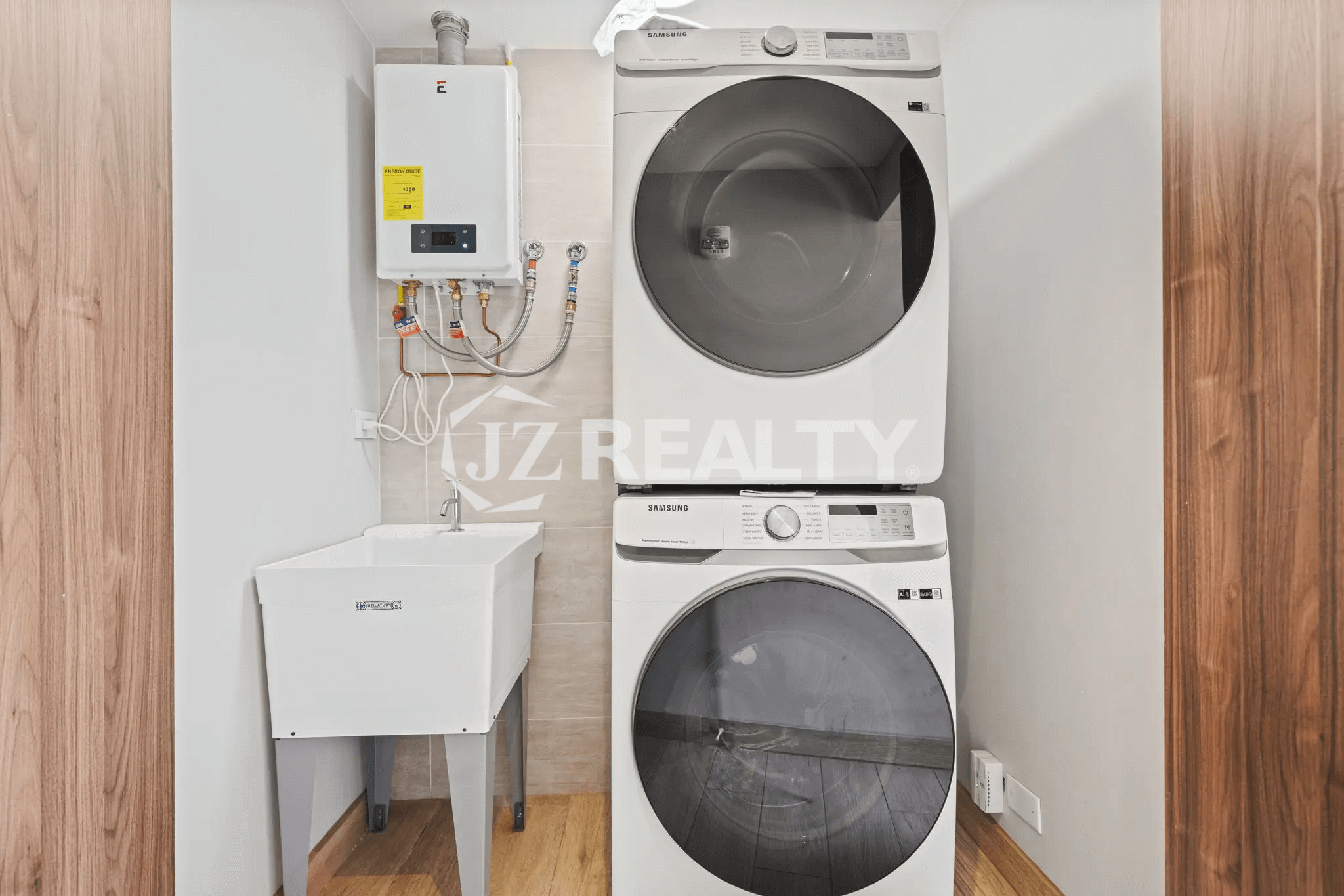 Dedicated laundry area in Porta al Sole Unit 13 with a stacked white washer and dryer unit, utility sink, and wall-mounted water heater.