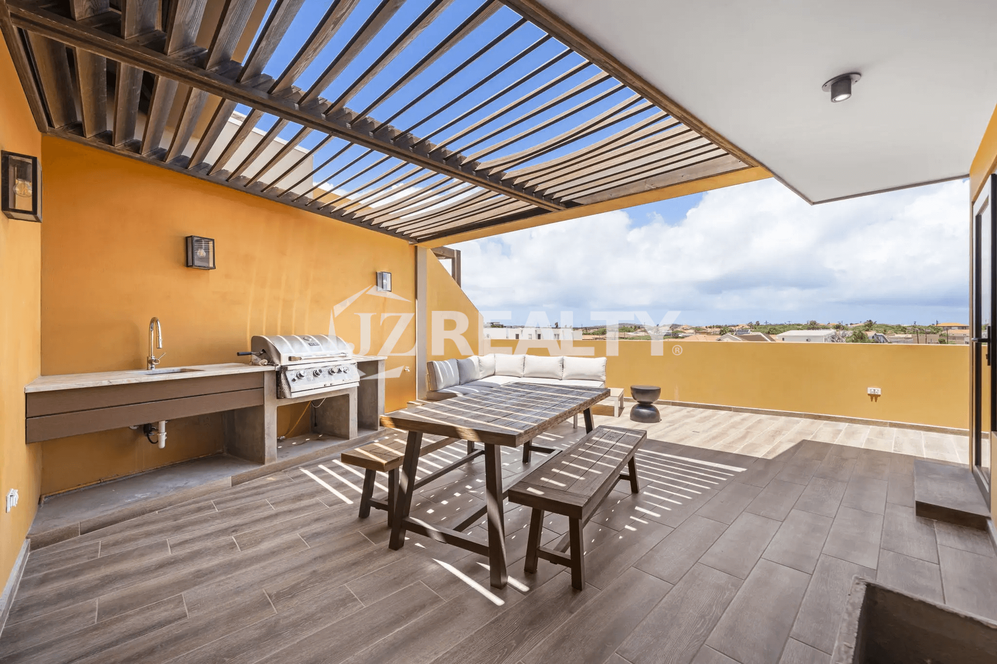 Rooftop deck at Porta al Sole Unit 13 with outdoor grill, sink, covered pergola, wooden dining table, and seating area.