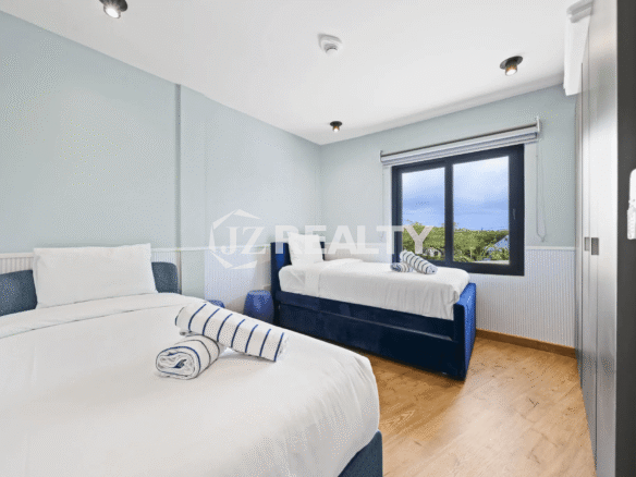 Second bedroom in Porta al Sole Unit 13 with light blue walls, two twin or day beds with blue velvet trim, and a window.