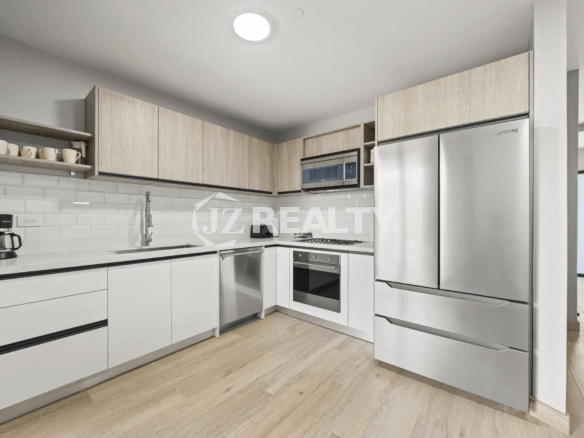 Fully-equipped modern kitchen with stainless steel Samsung refrigerator, oven, cooktop, and white subway tile backsplash in Porta al Sole Unit 14.