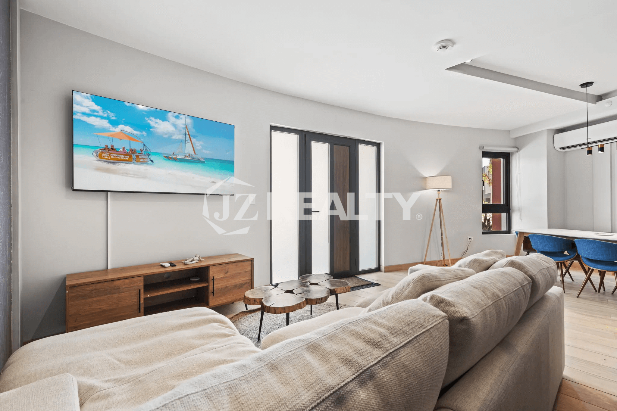Modern living room with sectional sofa, wooden TV console, and flat-screen TV in Porta al Sole Unit 14.