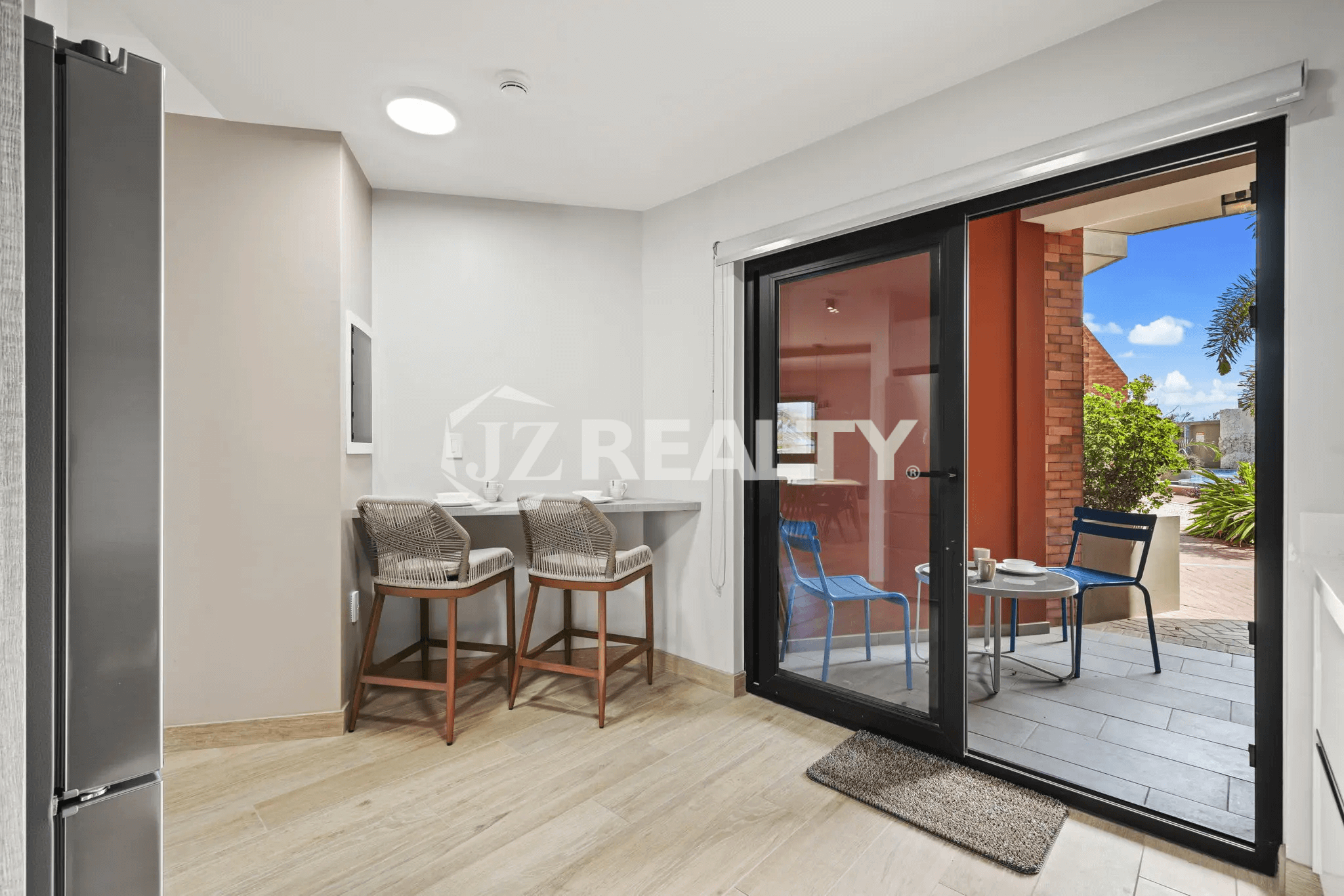 Indoor bar seating area adjacent to a sliding glass door leading to a small private patio in Porta al Sole Unit 14.