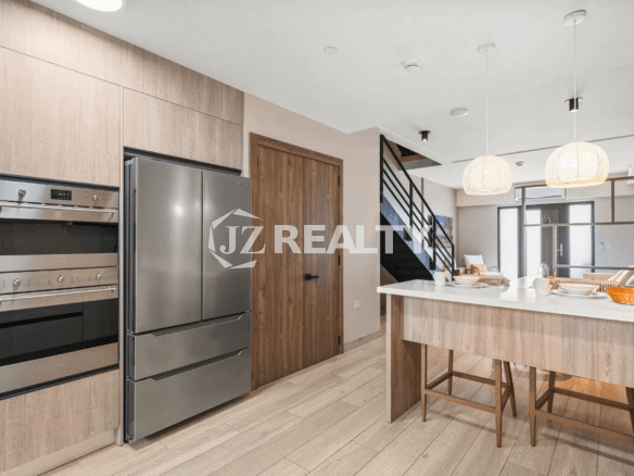 Detailed view of the kitchen area showcasing the stainless steel refrigerator, built-in double oven, and integrated cabinetry in Porta al Sole Unit 15.