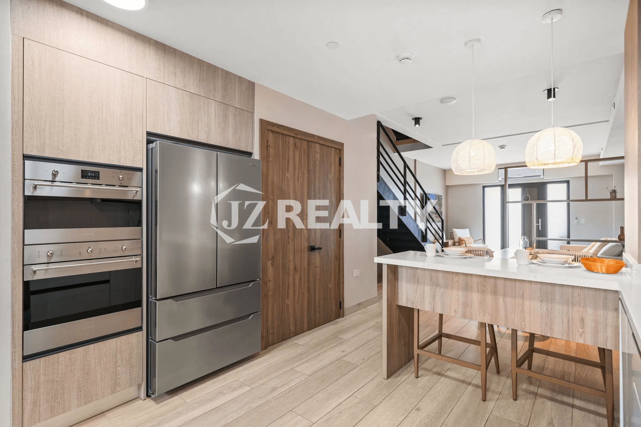 Detailed view of the kitchen area showcasing the stainless steel refrigerator, built-in double oven, and integrated cabinetry in Porta al Sole Unit 15.