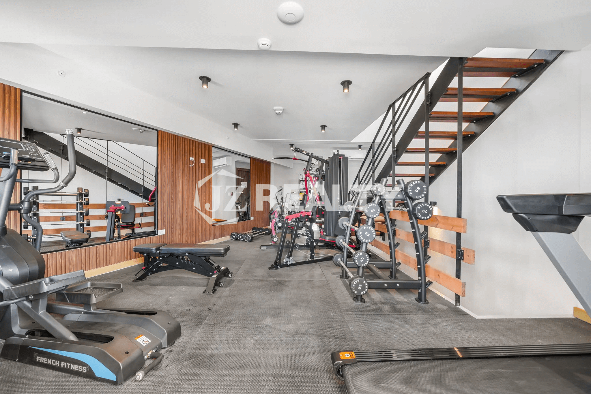 View of the community fitness center with a variety of equipment including treadmills, weights, a weight rack, and multi-functional gym machines.