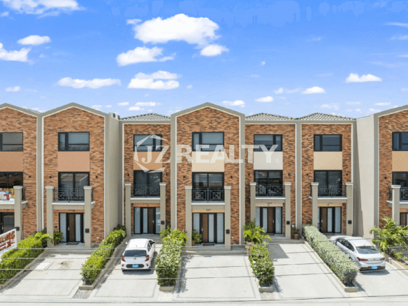 Front exterior view of the multi-story townhouses at Porta al Sole, featuring a mix of brick and stucco facades, private parking spots, and small front entrance balconies.