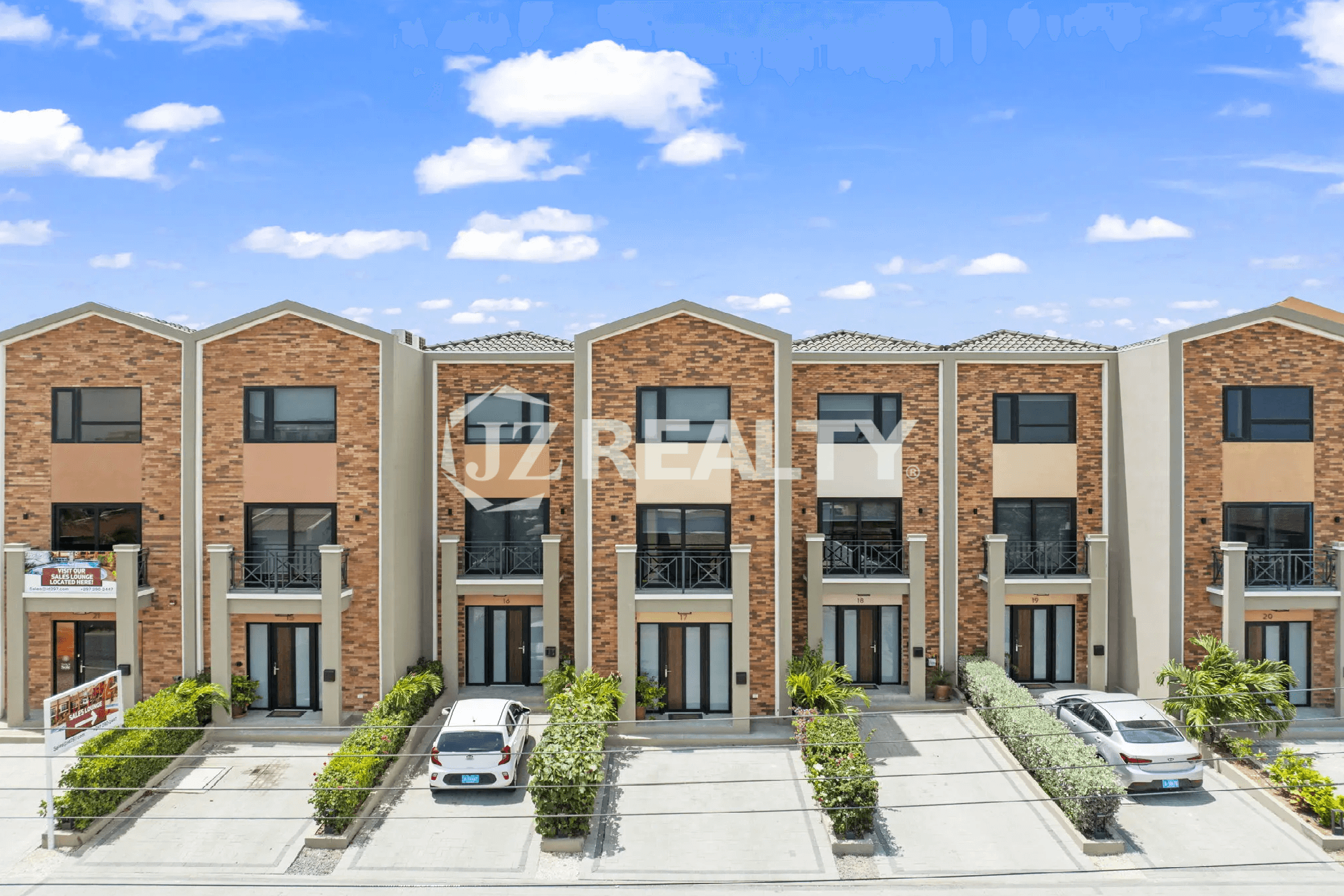Front exterior view of the multi-story townhouses at Porta al Sole, featuring a mix of brick and stucco facades, private parking spots, and small front entrance balconies.