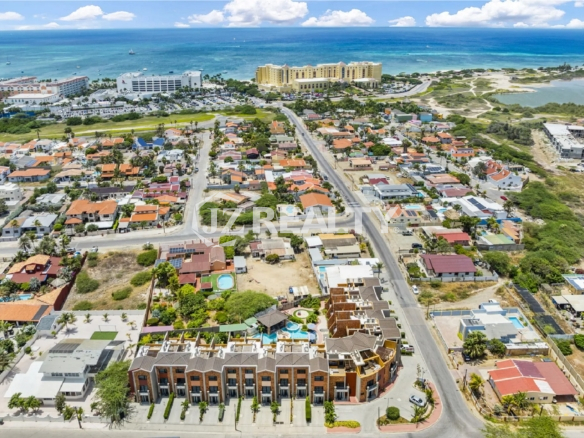 Wide aerial view of the Porta al Sole complex and surrounding neighborhood, showing its proximity to the ocean and Palm Beach hotels.