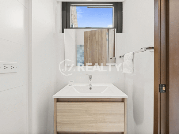 Half bathroom or patio-level bathroom in Porta al Sole Unit 8 featuring a single-sink vanity and a mirror.