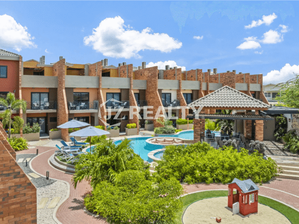 Aerial view of the Porta al Sole complex courtyard, highlighting the central swimming pool, lush landscaping, and the exterior of the townhouses.
