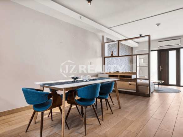 Dining space in Porta al Sole Unit 8 featuring a long table with blue upholstered chairs and a view into the living area.