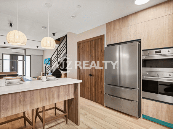 Detail of the kitchen in Porta al Sole Unit 8 showing the stainless steel French-door refrigerator and stacked built-in ovens.