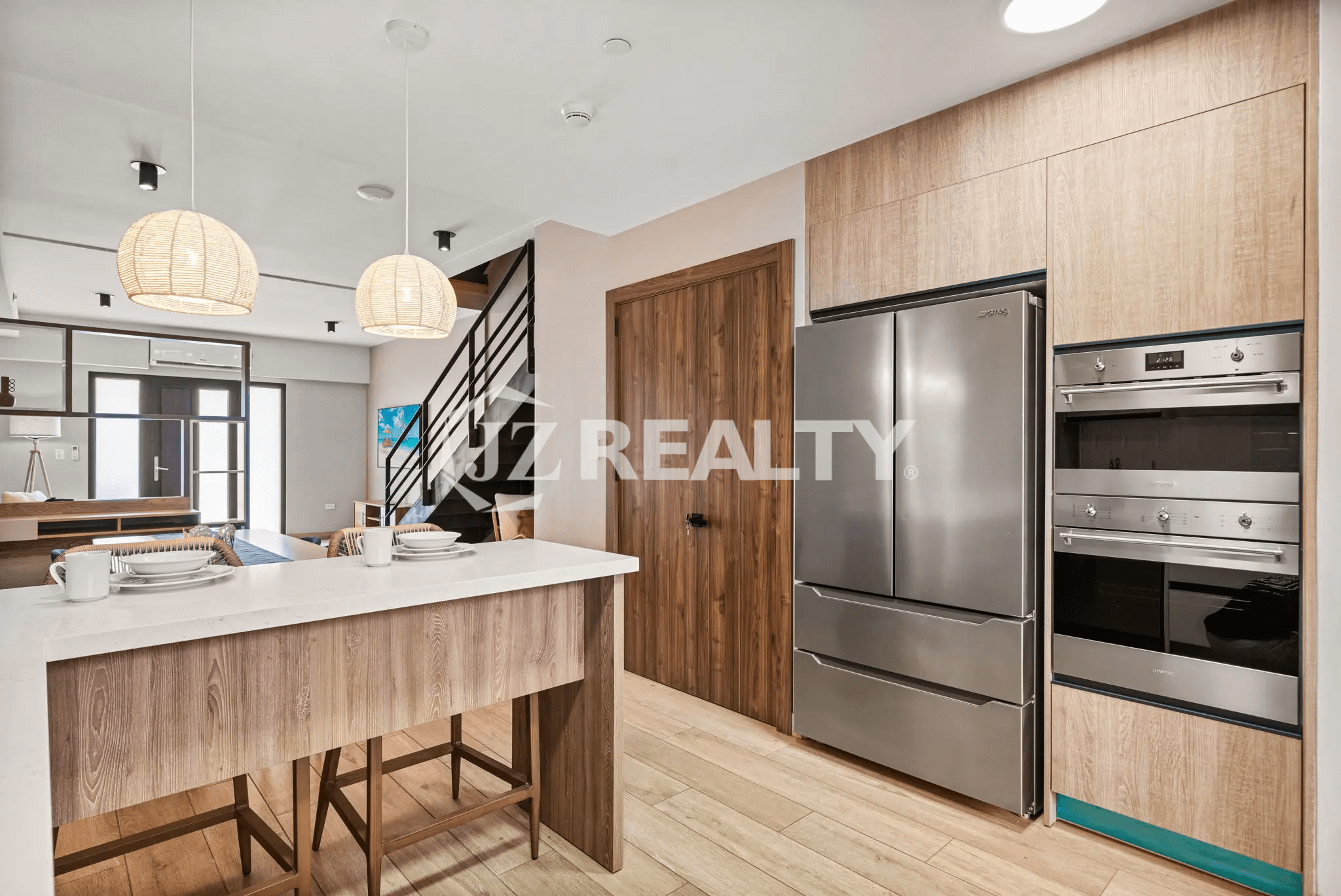 Detail of the kitchen in Porta al Sole Unit 8 showing the stainless steel French-door refrigerator and stacked built-in ovens.