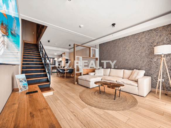 Living area in Porta al Sole Unit 8 showing the stairs, decorative room divider, and a patterned accent wall.