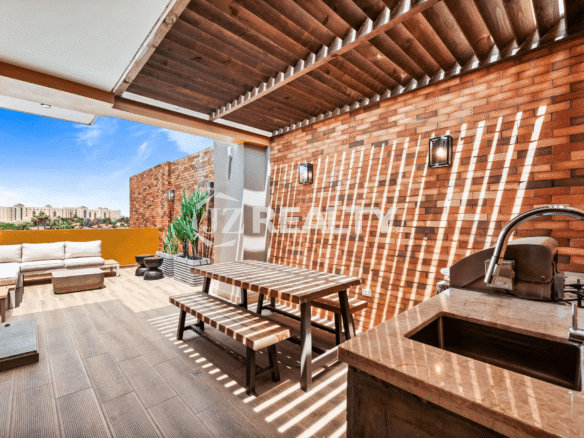 Outdoor patio on Floor 1 of Porta al Sole Unit 8, featuring an outdoor kitchen, dining table, and seating area under a pergola.