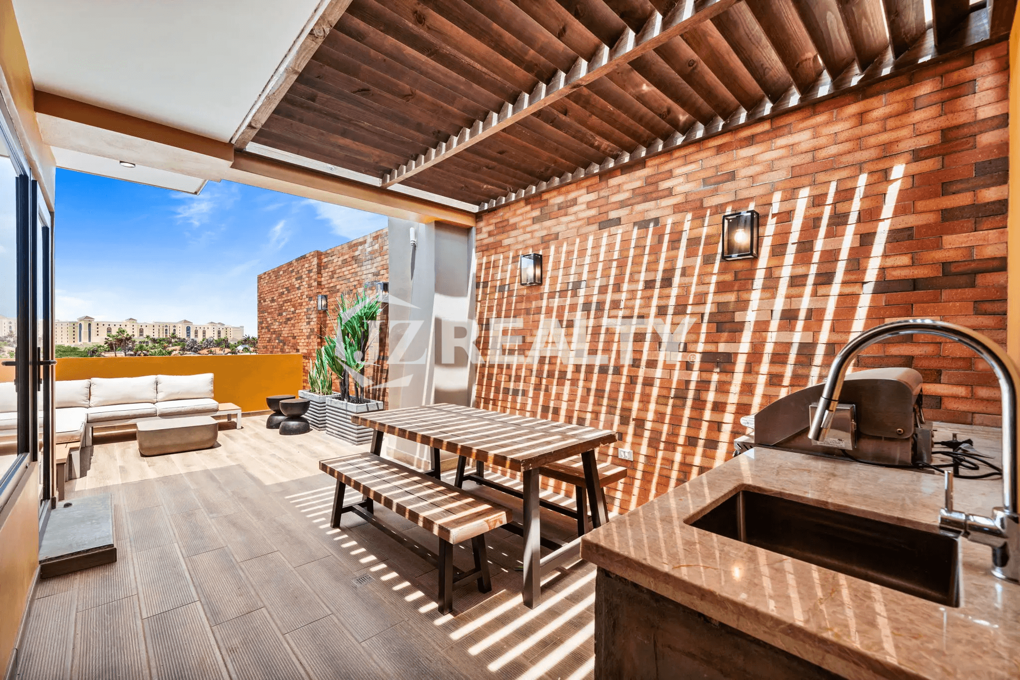 Outdoor patio on Floor 1 of Porta al Sole Unit 8, featuring an outdoor kitchen, dining table, and seating area under a pergola.