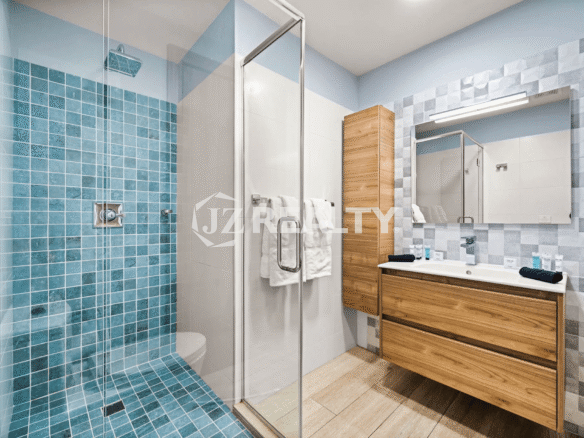 Primary Bathroom in Porta al Sole Unit 8 with a large walk-in shower and a floating wooden vanity with drawers.