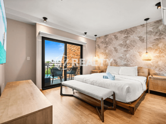 Close-up view of the Primary Bedroom (Floor 2) in Porta al Sole Unit 8, highlighting the tropical wallpaper and rattan pendant lights.