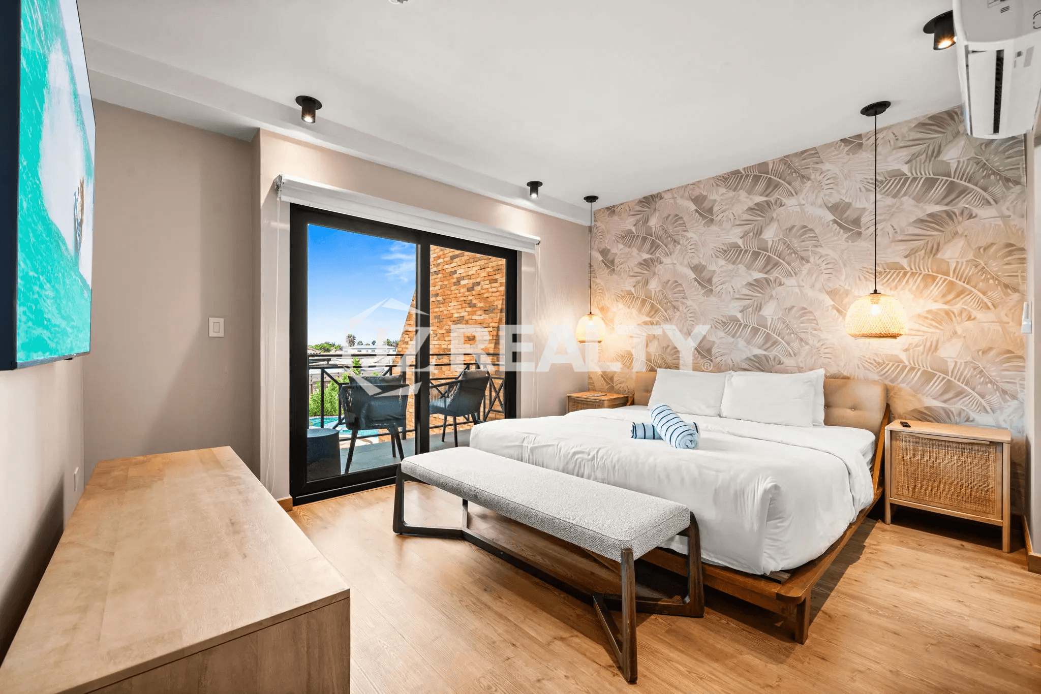 Close-up view of the Primary Bedroom (Floor 2) in Porta al Sole Unit 8, highlighting the tropical wallpaper and rattan pendant lights.