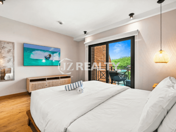 Primary Bedroom in Porta al Sole Unit 8 (Floor 2) featuring a queen bed, entertainment console, and sliding glass doors to a private balcony.