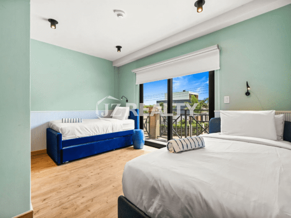 Second Bedroom (Floor 2) in Porta al Sole Unit 8, featuring two twin-size beds with blue velvet frames and access to a small balcony.