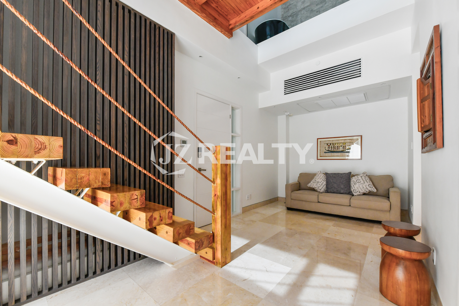 Coral Shell Condo 1E & 2E luxury loft modern entrance with a wooden staircase and stylish decor.