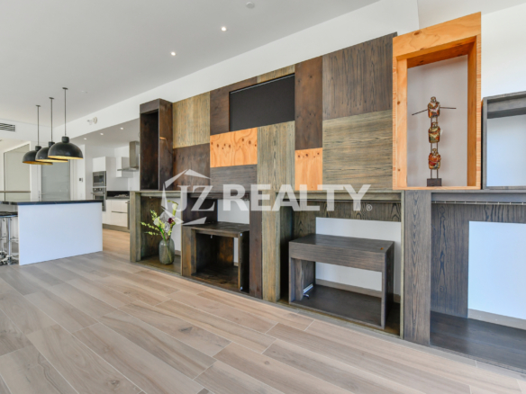 Sleek, open-concept kitchen and bar area in Coral Shell Condo 2E, featuring high-end appliances and a marble countertop.