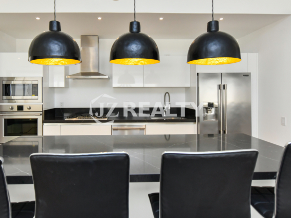 Spacious open-concept living area and kitchen in Coral Shell Condo 2E, featuring high ceilings, marble floors, and Italian kitchen furnishings.