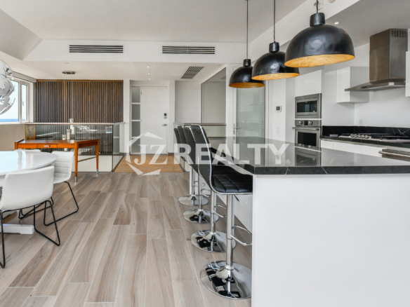 Chic lounge in Coral Shell Condo 1E, featuring a unique custom-built wall design and open living space.