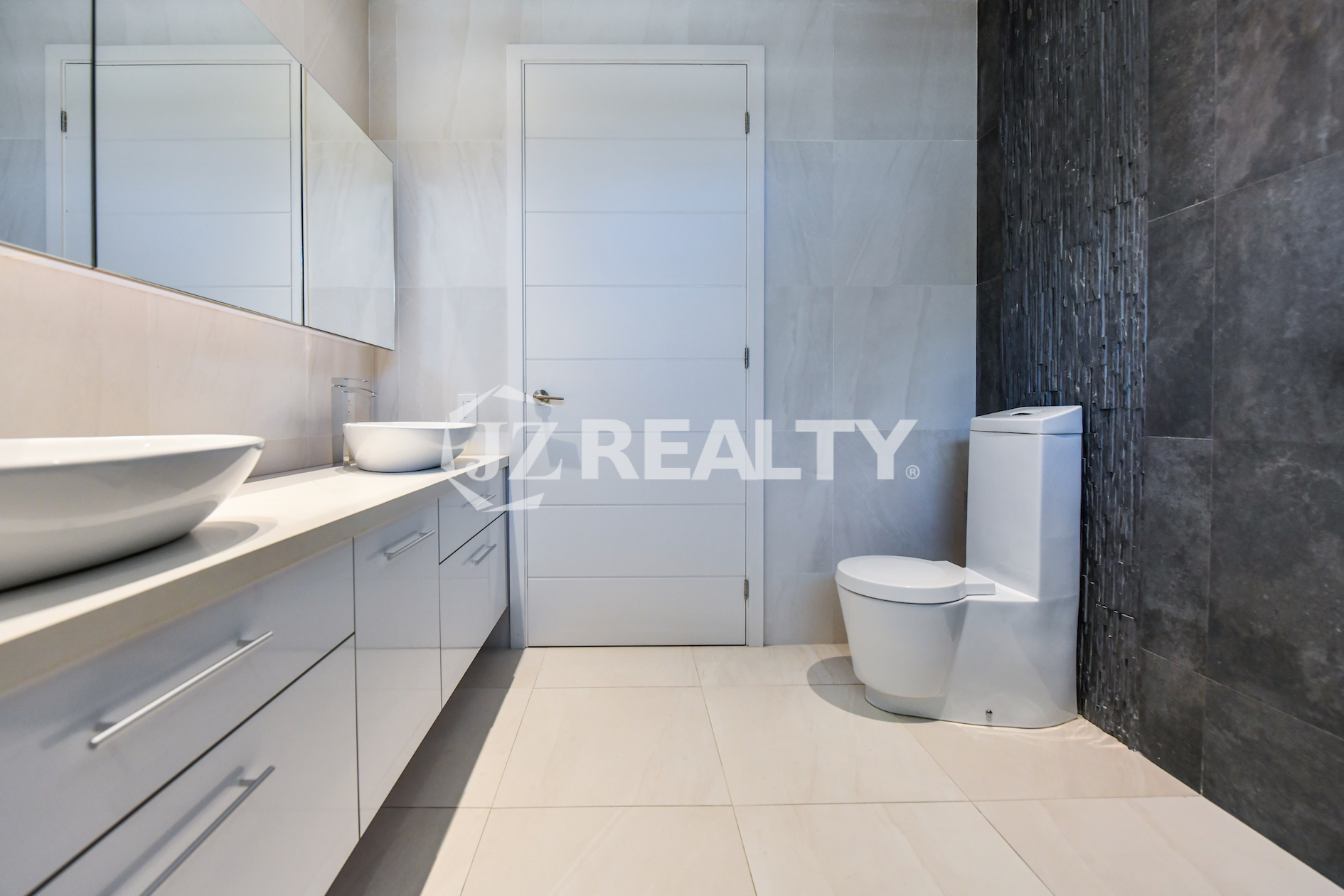 Coral Shell Condo 1E & 2E luxury loft bathroom with a striking contrast of dark and light tiles.