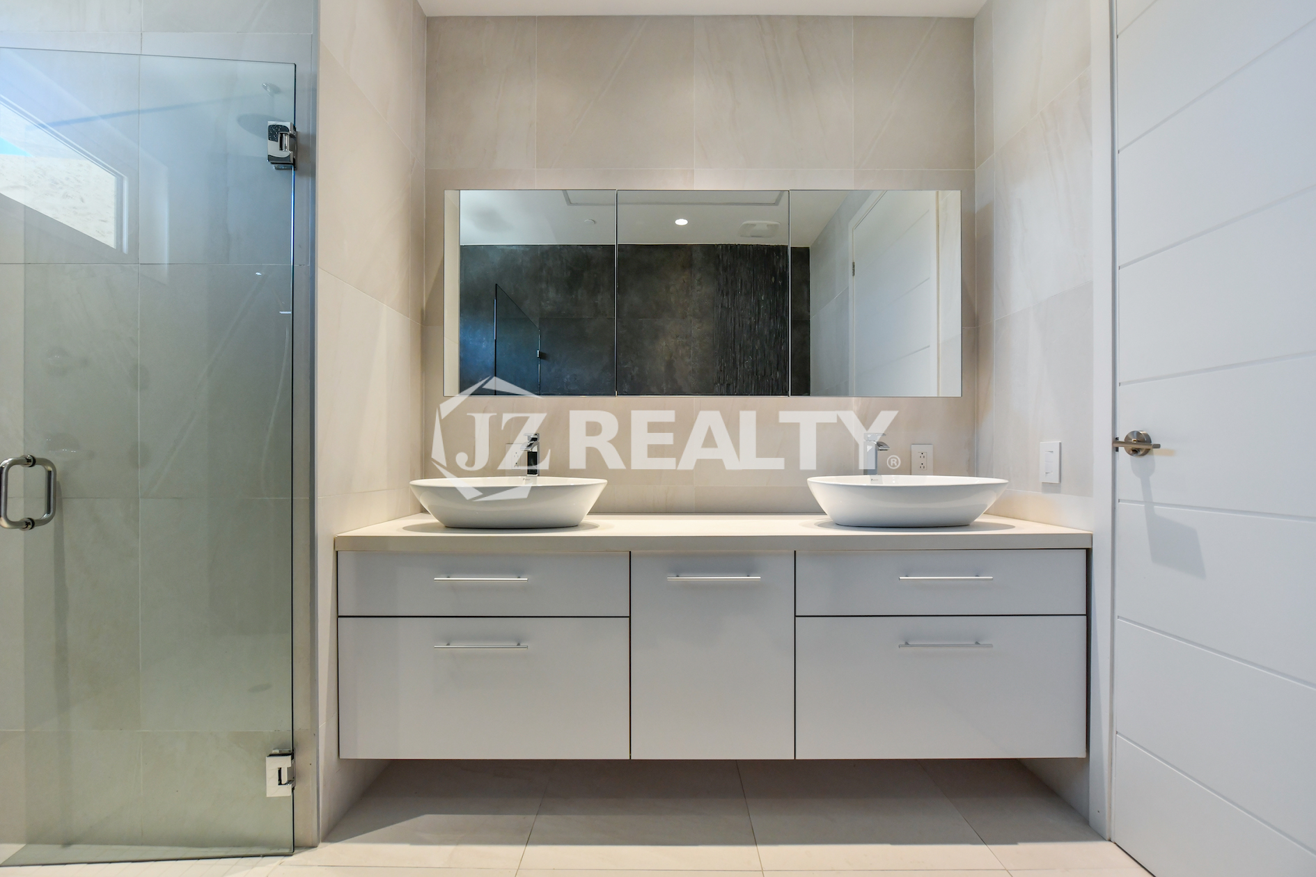 Coral Shell Condo 1E & 2E luxury loft bathroom with a double vanity, large mirrors, and glass shower.