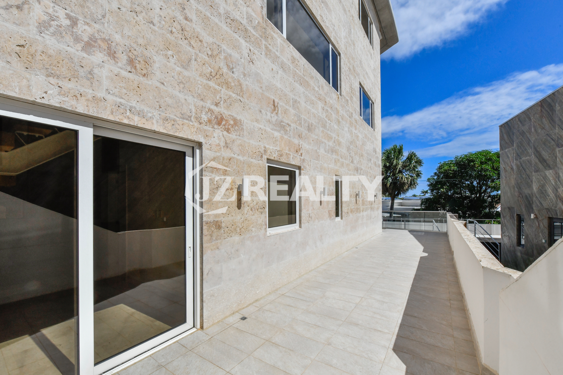Coral Shell Condo 1E & 2E luxury loft outdoor terrace with stone walls and modern lighting.