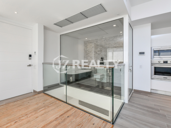 Elegant bathroom at Coral Shell Condo 1E in Oranjestad, Aruba, featuring a freestanding bathtub, see-through glass, and a privacy curtain.