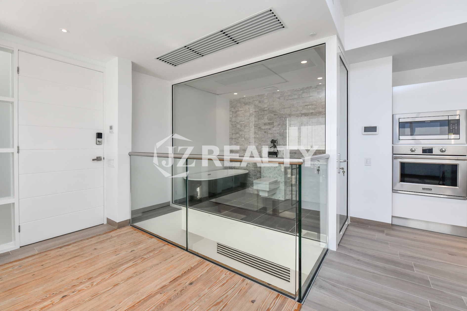 Elegant bathroom at Coral Shell Condo 1E in Oranjestad, Aruba, featuring a freestanding bathtub, see-through glass, and a privacy curtain.