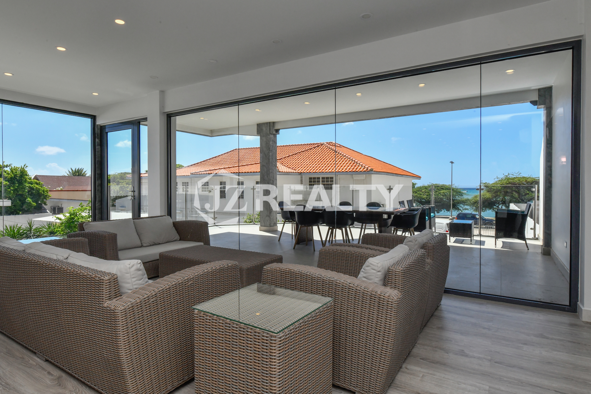 Indoor-outdoor living area with ocean-view terrace in Condo 1H, Coral Shell Condominium, Aruba.