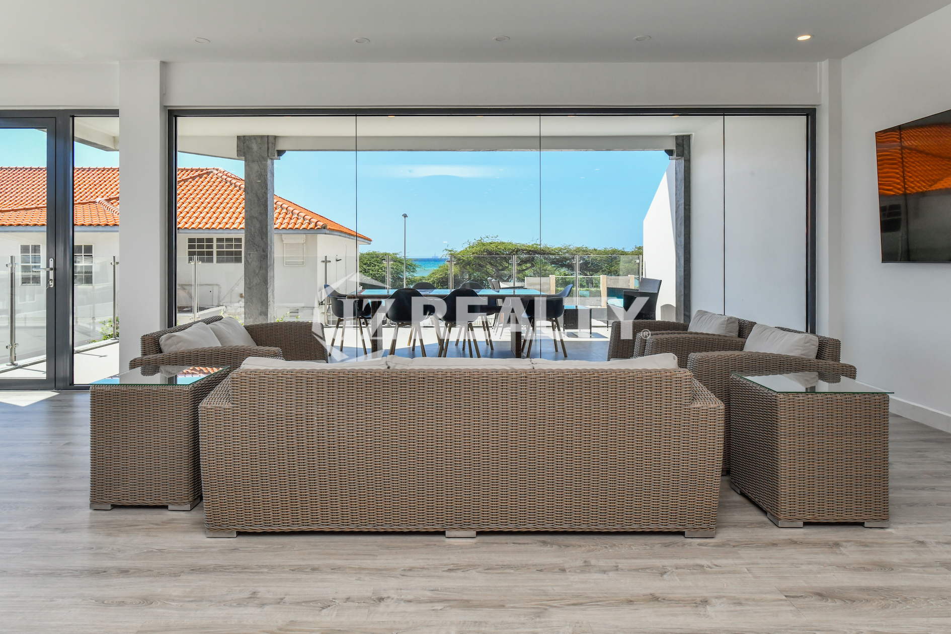 Spacious living room with direct access to an ocean-view terrace in Condo 1H, Coral Shell Condominium, Aruba.