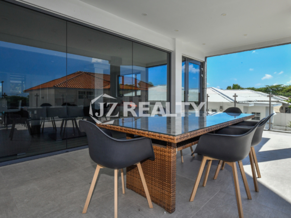 Ocean-view balcony with a stylish dining table at Coral Shell Condo 1H, Aruba.