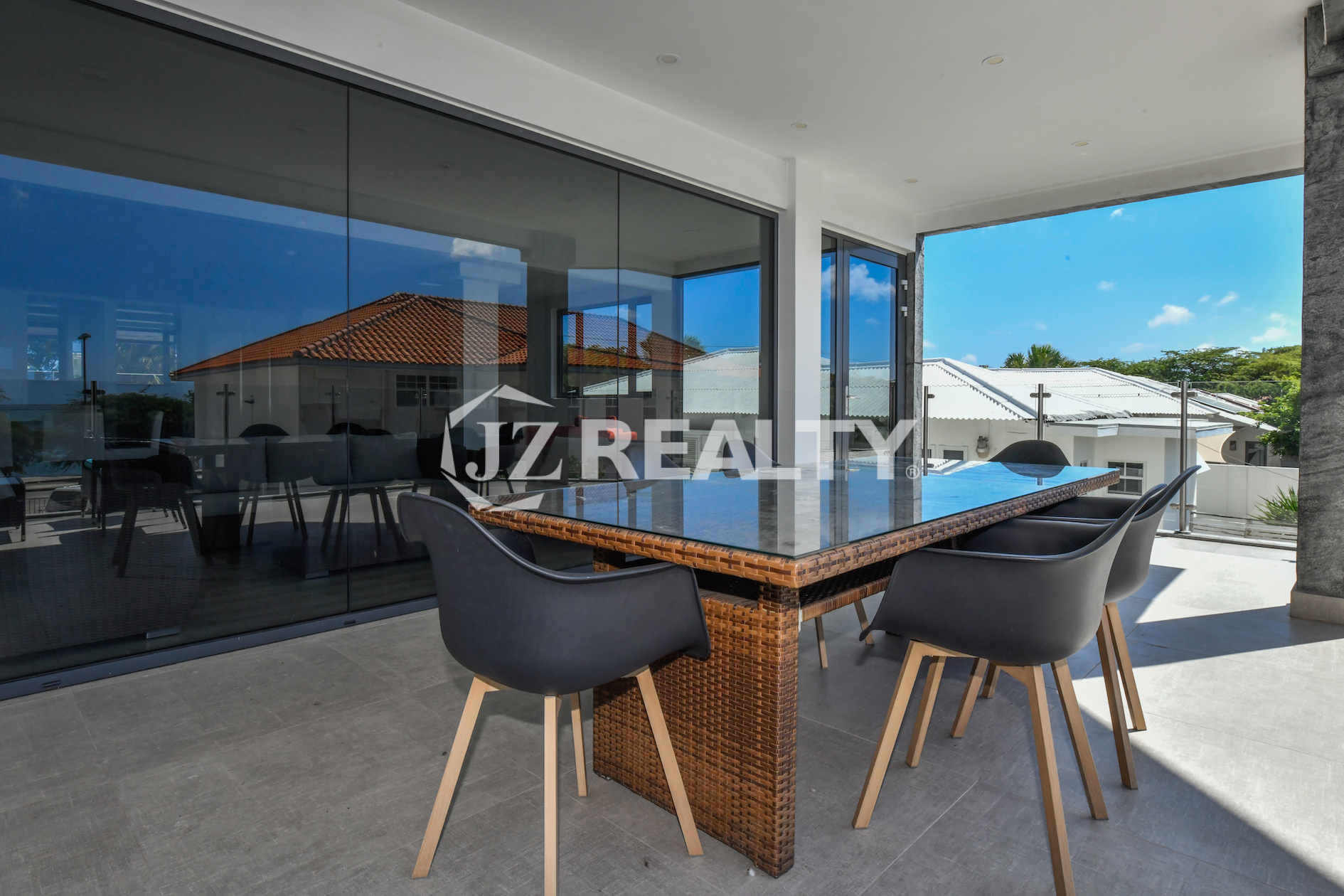 Ocean-view balcony with a stylish dining table at Coral Shell Condo 1H, Aruba.