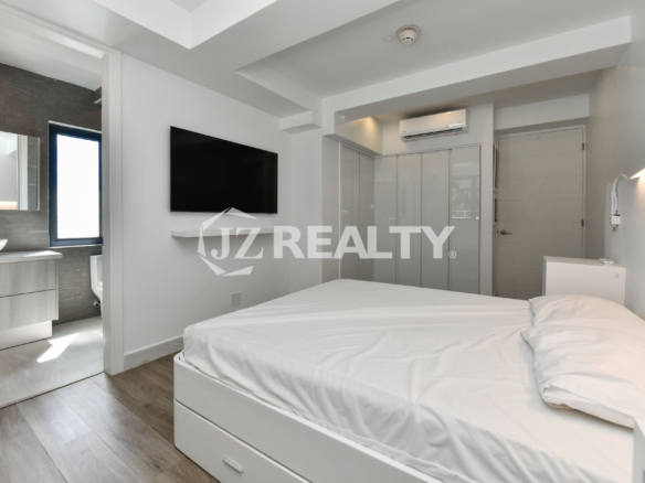 Master bedroom with TV and built-in closet at Coral Shell Condo 1H, Aruba.